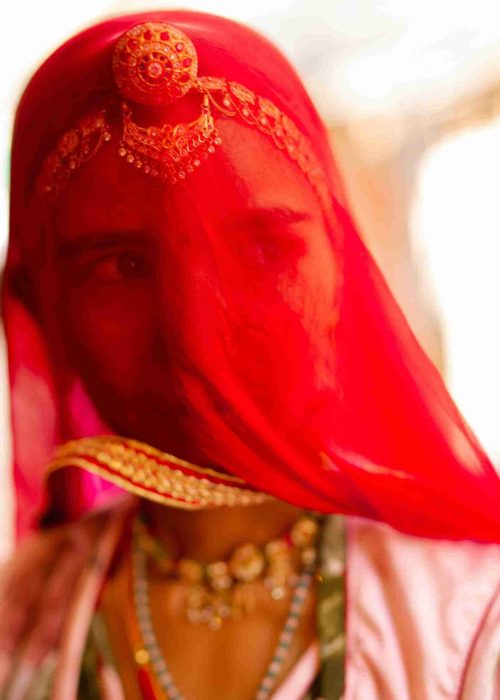 Woman Wearing Traditional Clothes and a Red Mesh Veil Covering Her Face_11zon